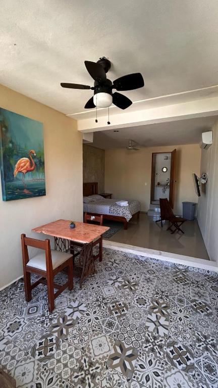 a living room with a ceiling fan and a table at Departamento Privado y Amplio en Zona Norte con Wifi cerca Centro in Mérida