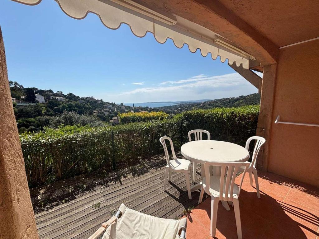 - une table et des chaises sur une terrasse avec vue dans l'établissement Les Issambres T2 rénové avec piscine et parking - FR-1-226-561, à Roquebrune-sur Argens