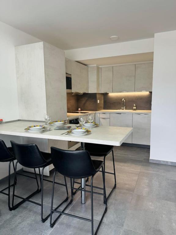 une cuisine avec une grande table blanche et des chaises dans l'établissement L'orée du lac tout confort 3 garage privatif, au Bourget-du-Lac