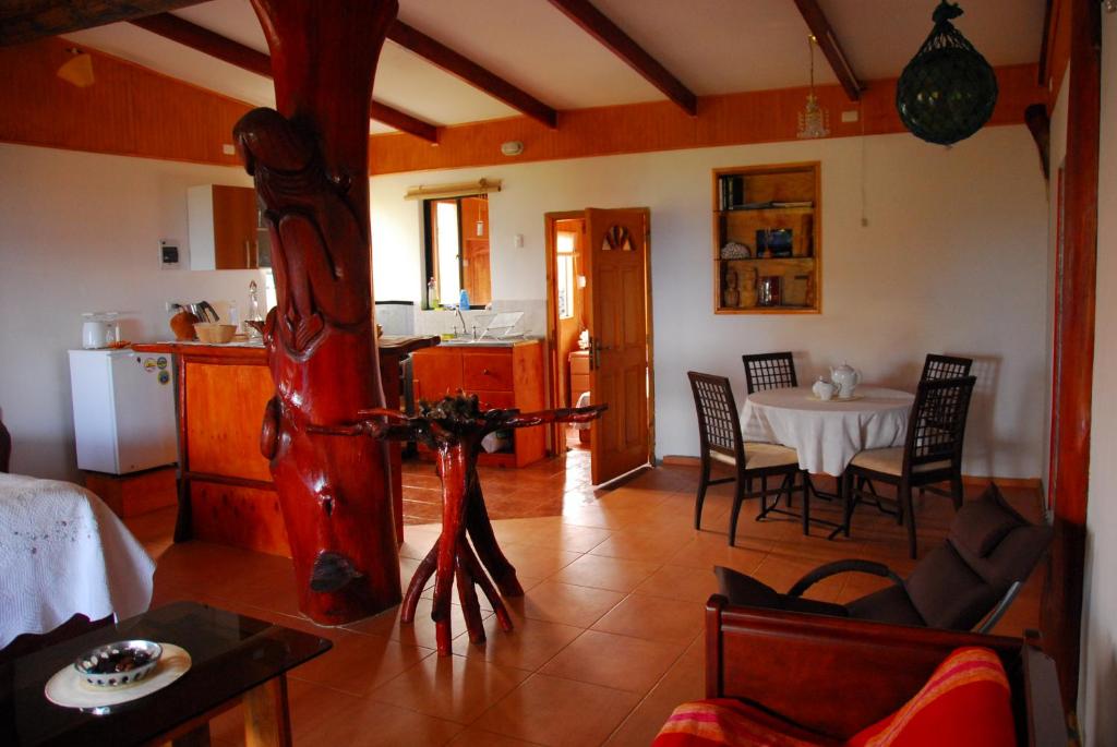 a kitchen and a living room with a table and chairs at Cabañas Moai in Hanga Roa