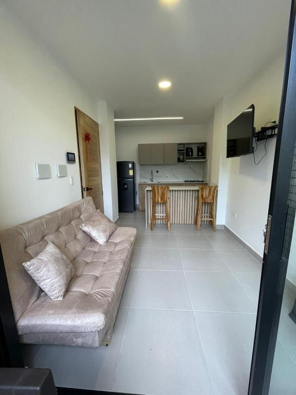 a living room with a couch and a kitchen at Cozy apartment in Apartadó in Apartadó