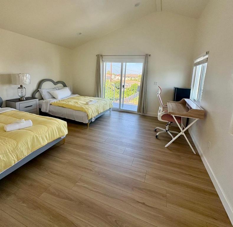 ein Schlafzimmer mit zwei Betten und einem Schreibtisch und einem Stuhl in der Unterkunft 20ppl Russell Monterey Park Cozy Home Quiet & Central Near Restaurants DTLA DISNY HOLLYWOOD in Monterey Park