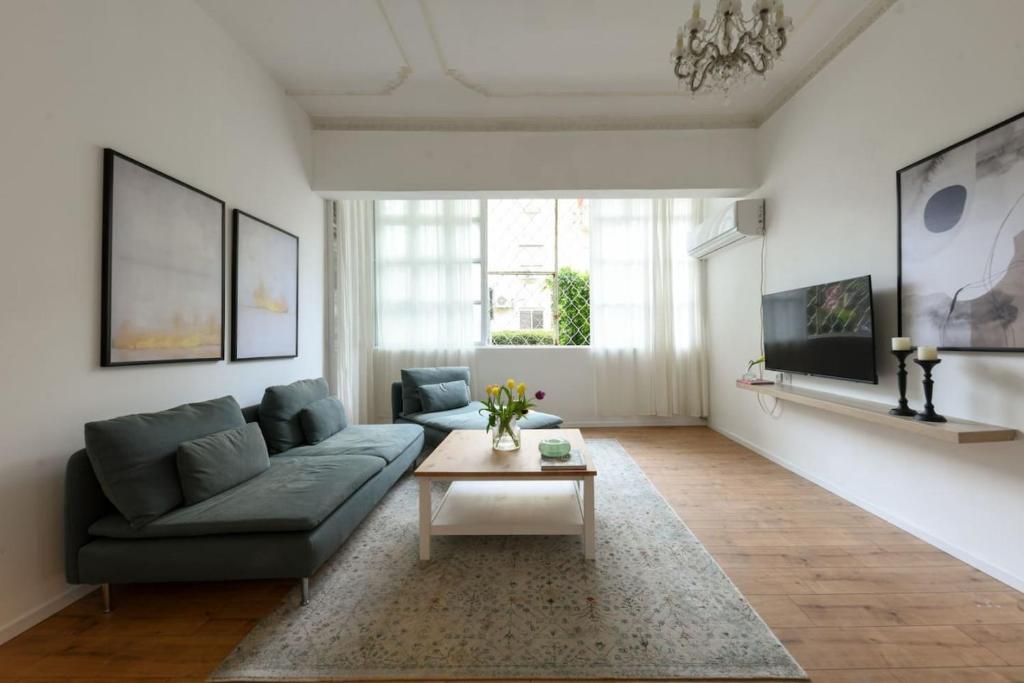 a living room with a couch and a coffee table at Homey & Spacious 2BR Apt in the Heart of Tel-Aviv by Sea N' Rent in Tel Aviv