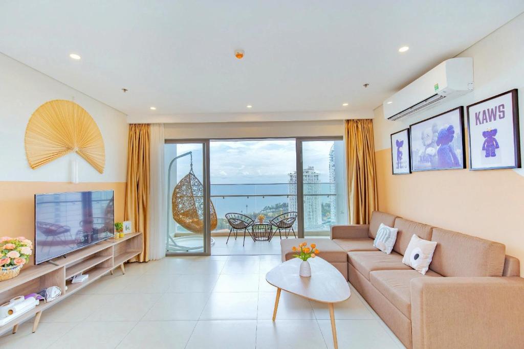 a living room with a couch and a tv at T- HOLYDAY THESONG APARTMENT - Căn Hộ Nghỉ Dưỡng Cao Cấp Gần Biển Thành Phố Vũng Tàu in Vung Tau