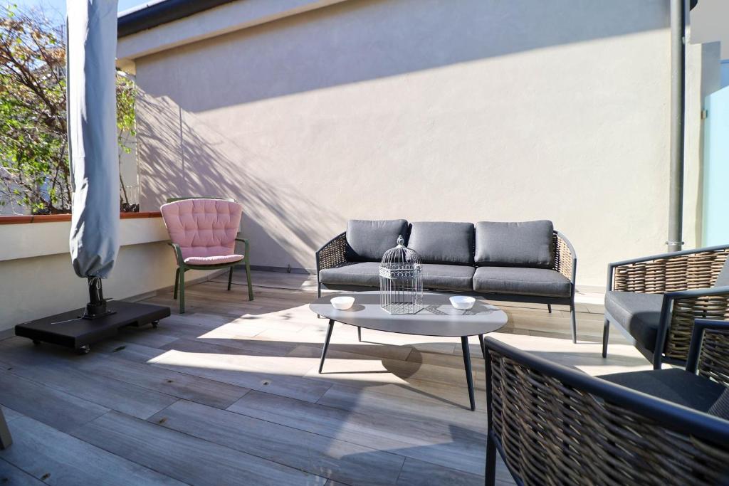 a patio with a couch and two chairs and a table at Vicolo dei Signori By Case al Lago in Desenzano del Garda