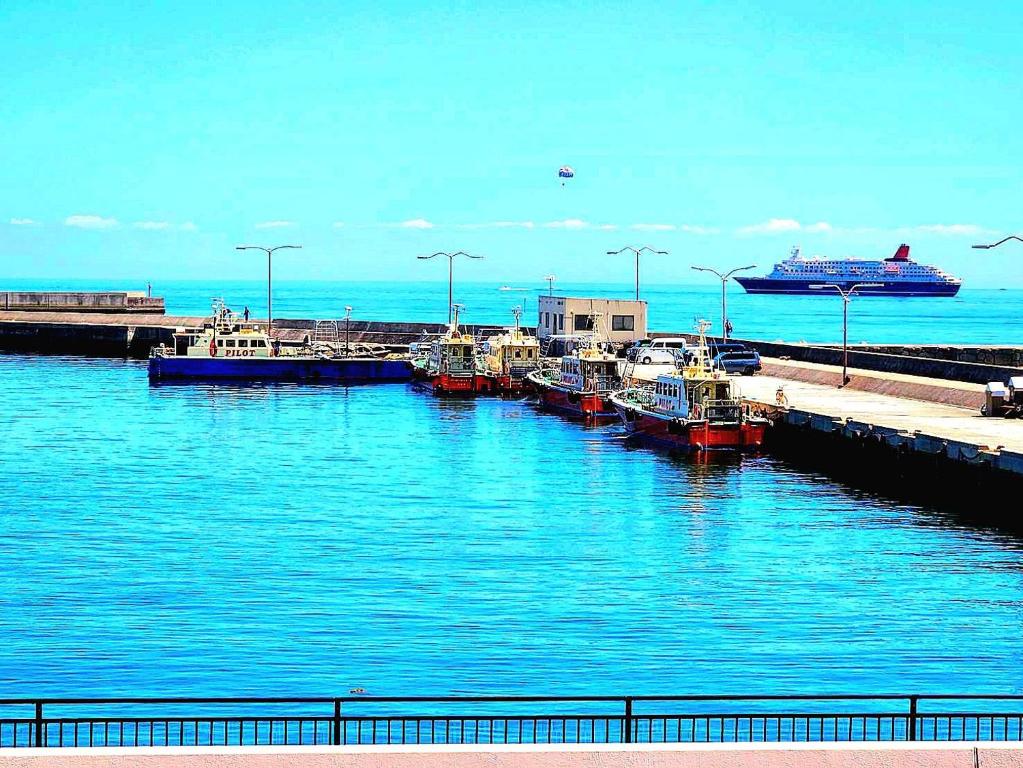 a group of boats docked at a dock with a cruise ship at 貸別荘 Dolphiｎ AQUA 淡路島 in Sumoto