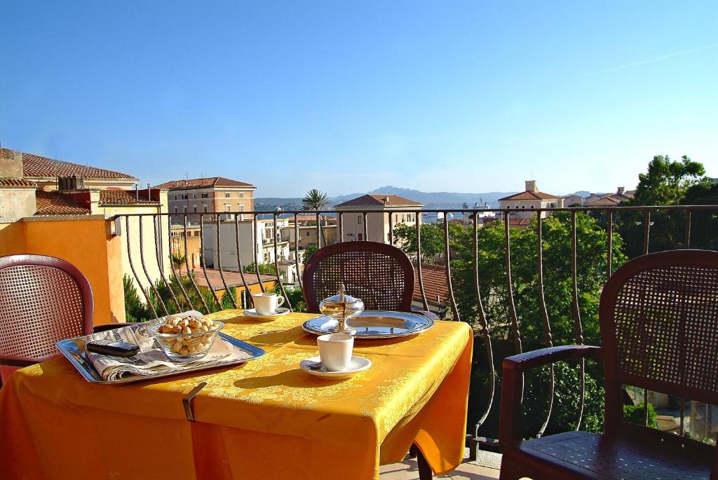 einen Tisch mit einem gelben Tischtuch auf dem Balkon in der Unterkunft Hotel Delle Isole in La Maddalena
