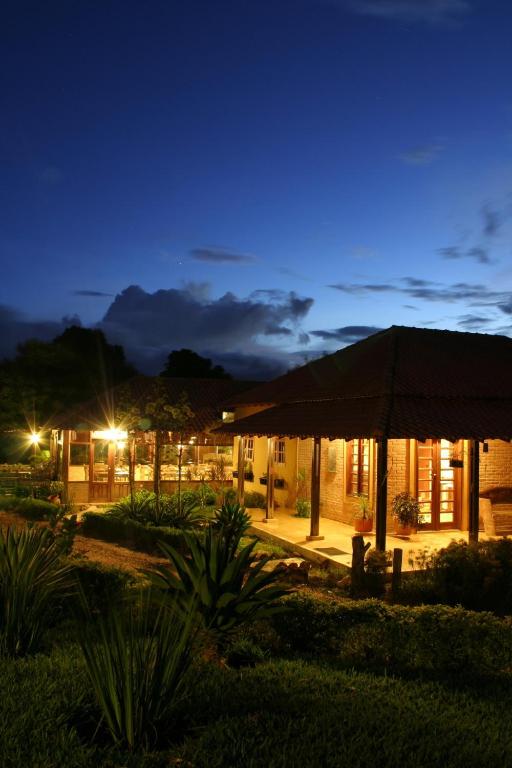 a building with an umbrella at night at Pousada Vale das Araras in Cavalcante