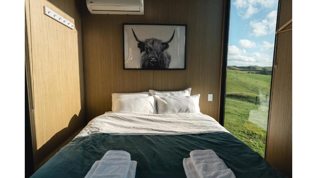 Posto letto in camera con foto di un toro di Mighty Tiny House 2 by Tiny Away a Ruawaro