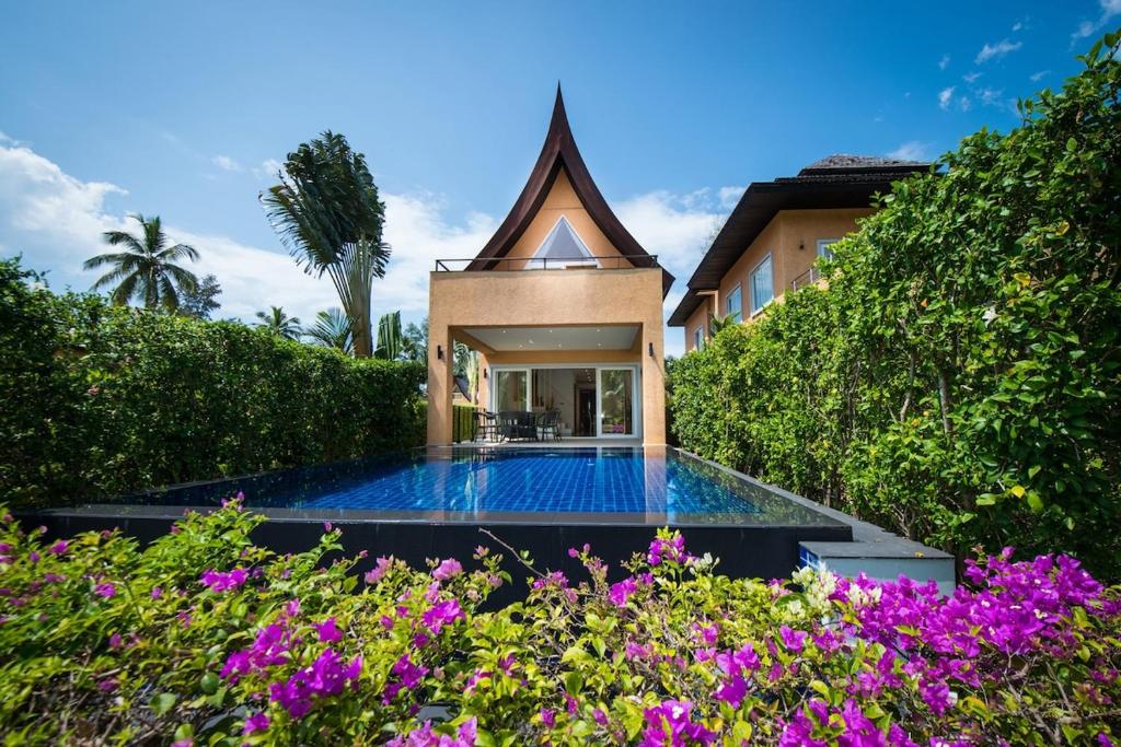 una casa con una piscina en un jardín con flores en Blue Chill private Pool Villa - Koh Chang, en Ko Chang