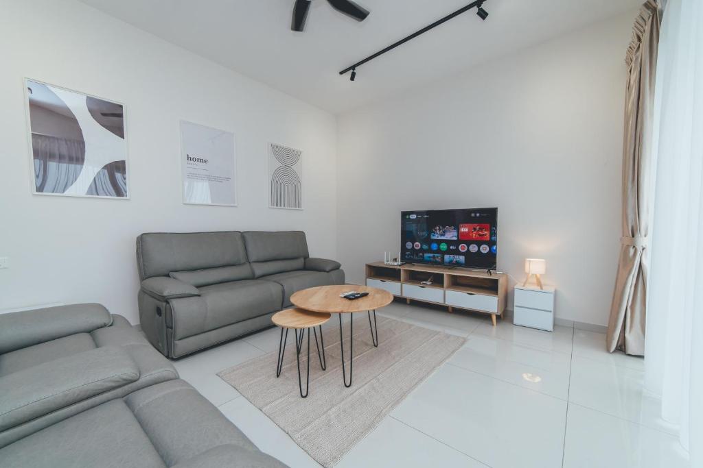 a living room with a couch and a table and a tv at Danga Bay Coastal Comfort 3BR 8Pax w 3Balcony by Our Stay in Johor Bahru