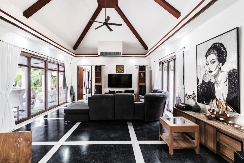 a living room with a couch and a tv at Villa Banyak | Luxury 4Br villa with nice terrace and personal playground in Ban Saiyuan (1)