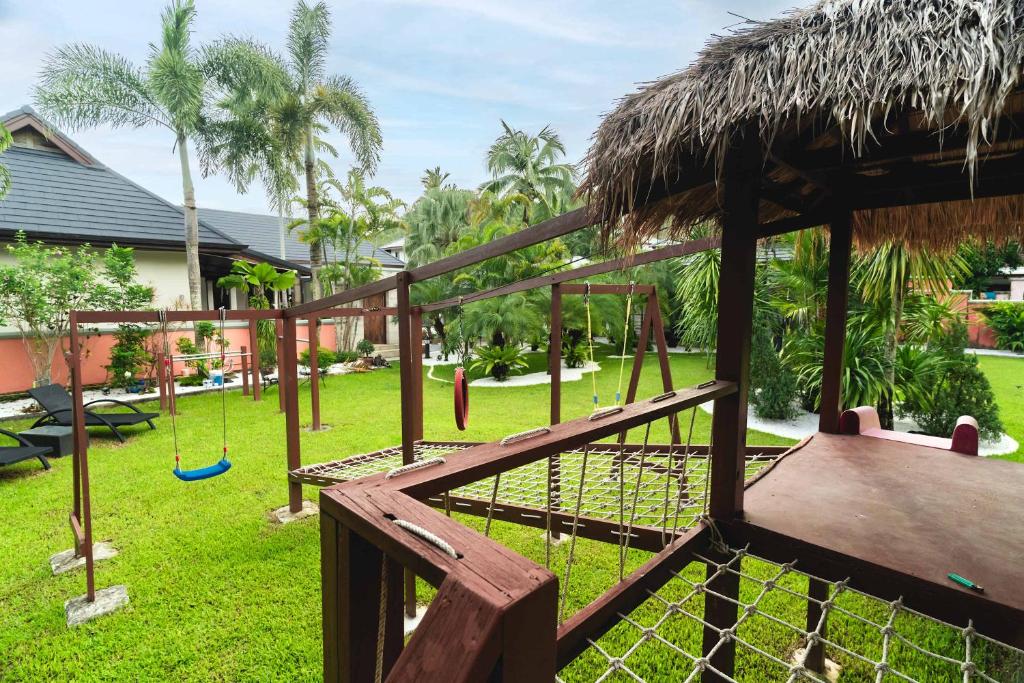 a playground with a swing set and a grass roof at Villa Banyak | Luxury 4Br villa with nice terrace and personal playground in Ban Saiyuan (1)