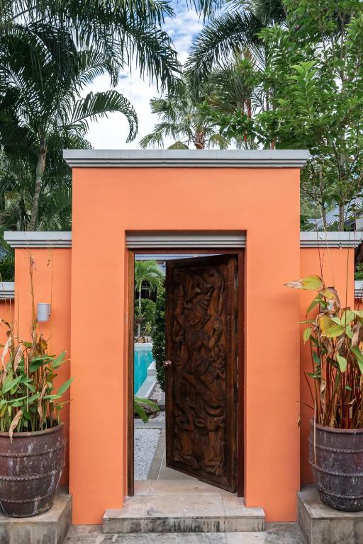 a small orange building with a wooden door at Villa Banyak | Luxury 4Br villa with nice terrace and personal playground in Ban Saiyuan (1)