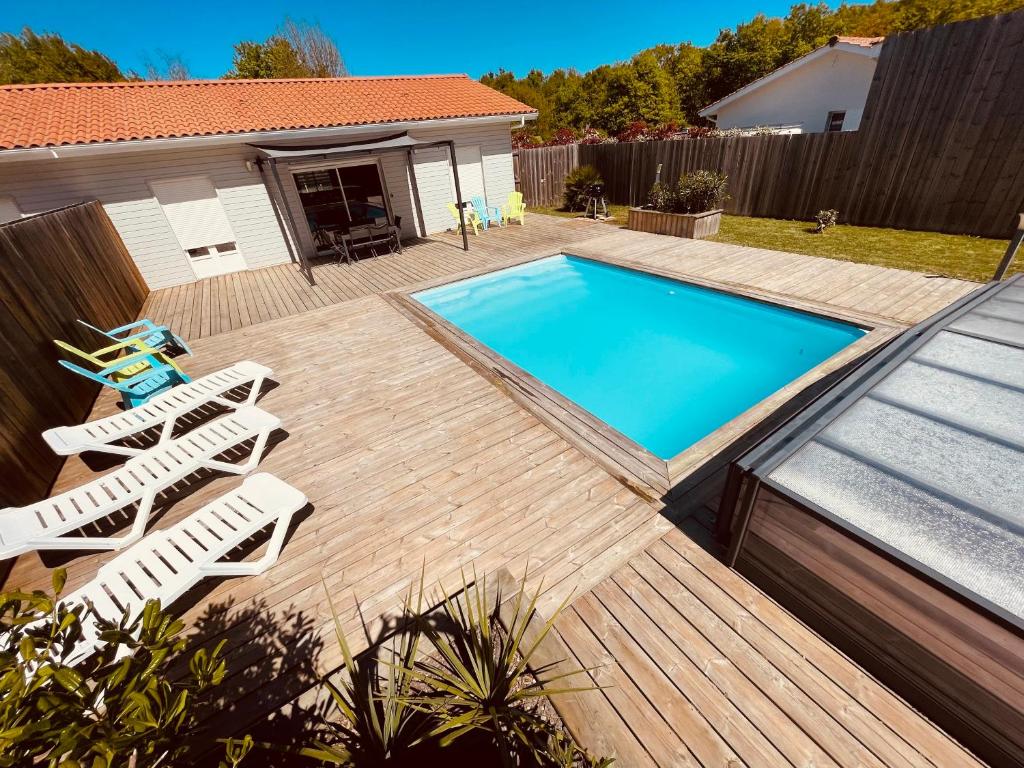 une terrasse avec des chaises et une piscine dans l'établissement Maison Papillon piscine couverte, à Grayan-et-lʼHôpital