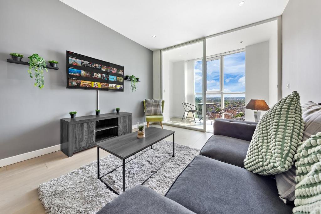 a living room with a couch and a table at Sky Scraper London Luxury 1BR Roof Terrace and Gym in London