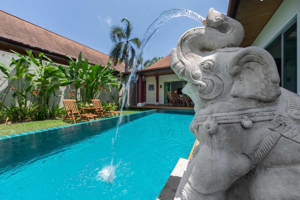 una fuente frente a una piscina en Villa Kaheru | 3 bedroom priavate pool villa | Kokyang Estate, en Nai Harn Beach