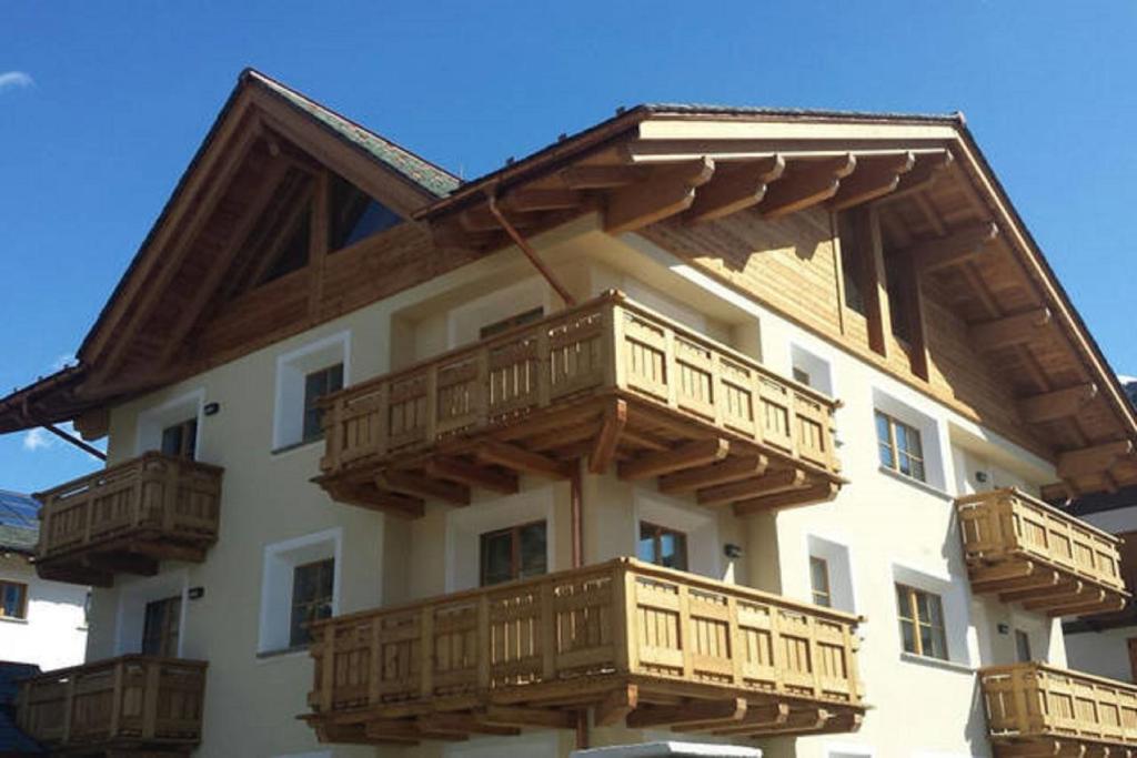 a building with wooden balconies on the side of it at Appartamento Zepp in Bormio