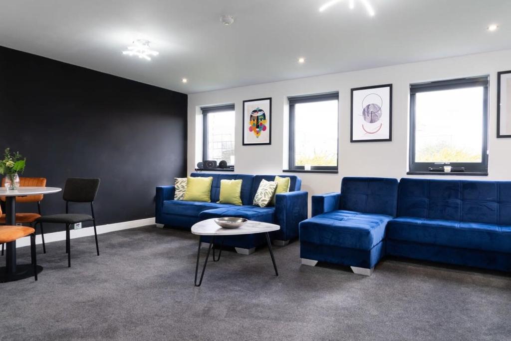 a living room with a blue couch and a table at Superior 1-Bed Apartment with 2 Sofa Beds Sleeps 6 in Peterborough