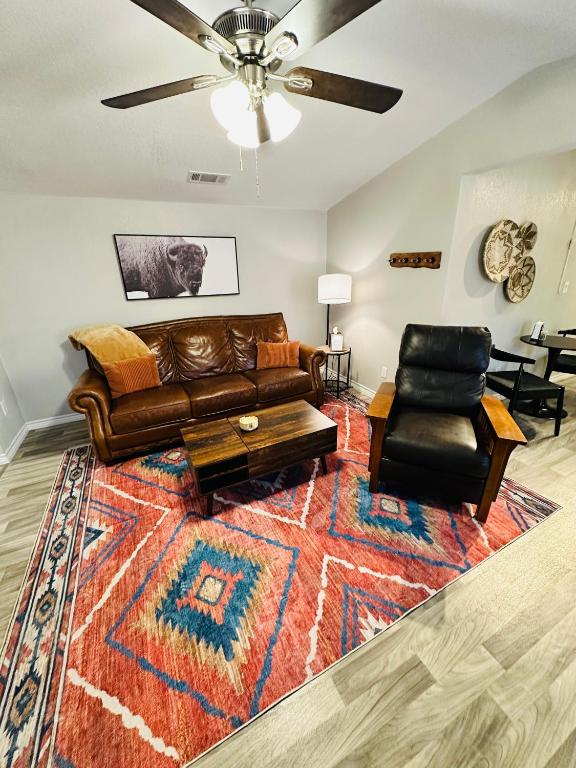 een woonkamer met een leren bank en een tapijt bij Golden Hour Getaway in Springtown