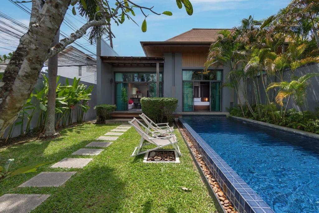 a backyard with a swimming pool and a house at VILLA ATA | Private Pool | Saiyuan Estate by Tropiclook | Nai harn beach in Nai Harn Beach
