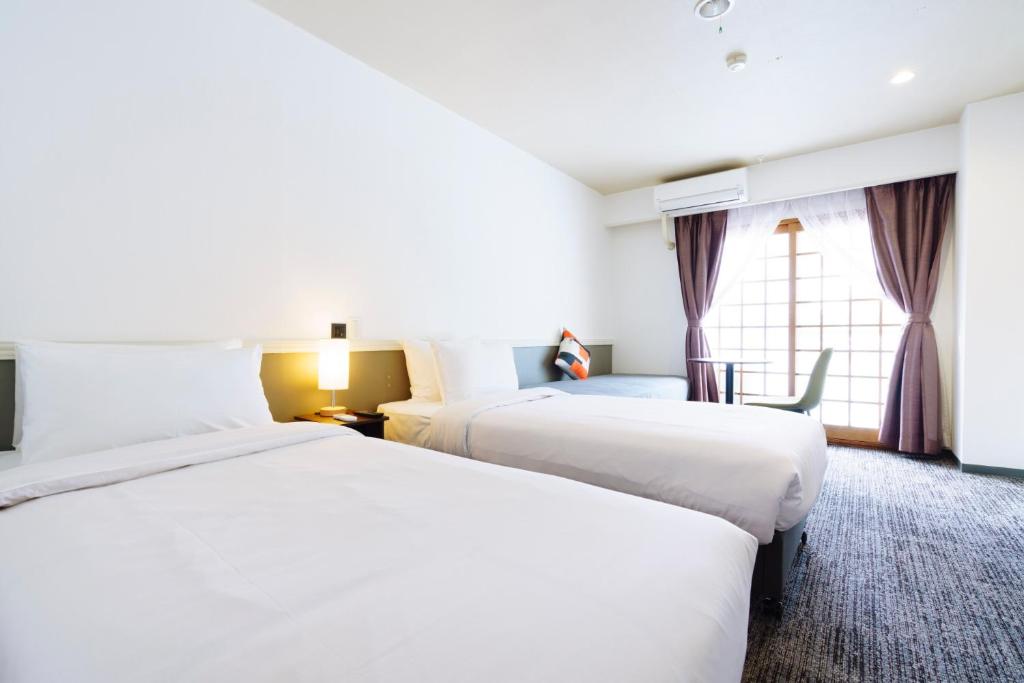 Postel nebo postele na pokoji v ubytování Hakuba Gateway Hotel