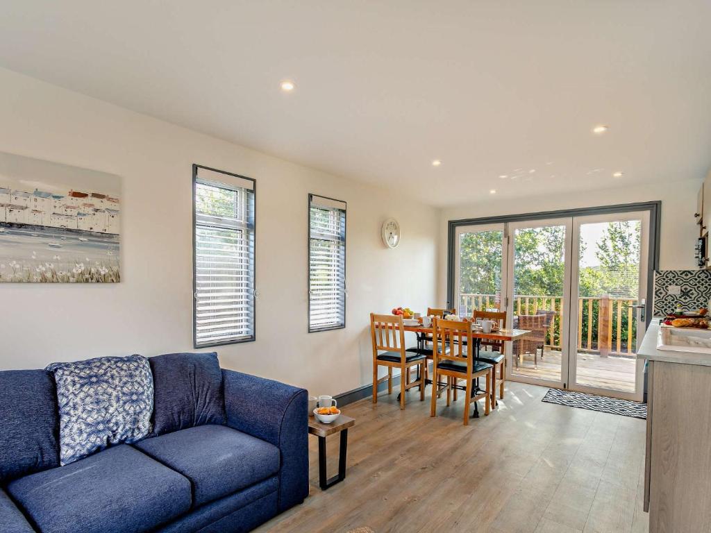 a living room with a blue couch and a table at 2 Bed in Westward Ho 95625 in Westward Ho