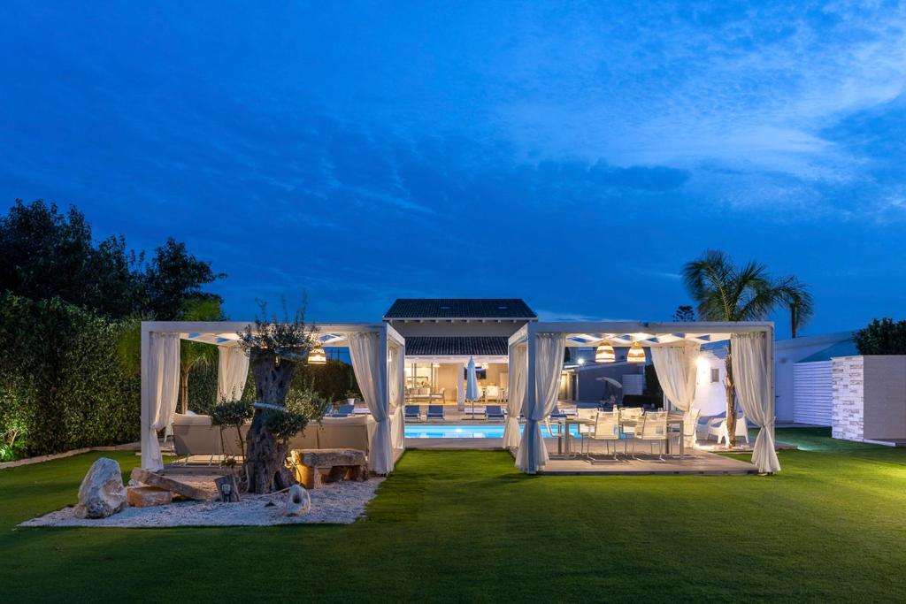 une cour avec un kiosque et une piscine dans l'établissement Villa Gemma mare e piscina riscaldata, à Santa Maria Del Focallo