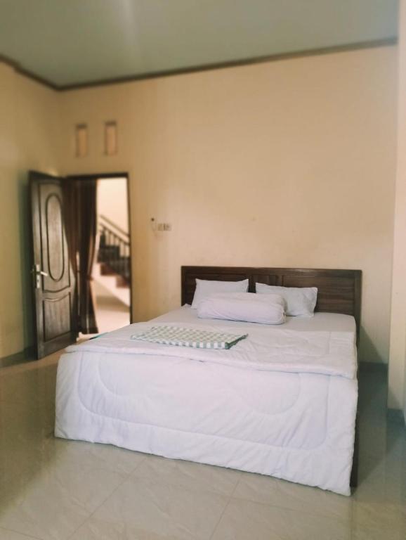 a bedroom with a large white bed with white sheets at PENDIK Home Stay in Labuan Bajo