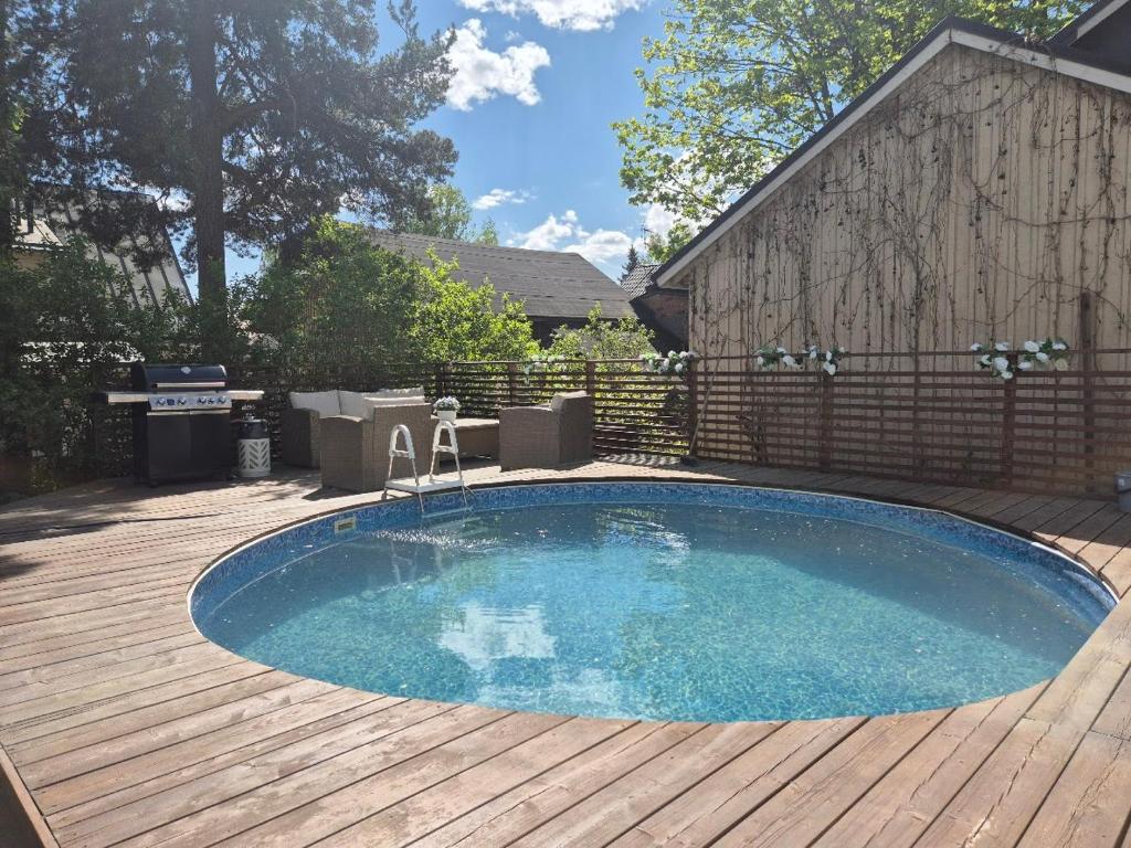 una pequeña piscina en una terraza de madera en Villa Mosahiisi Charming Poolside Getaway, en Helsinki