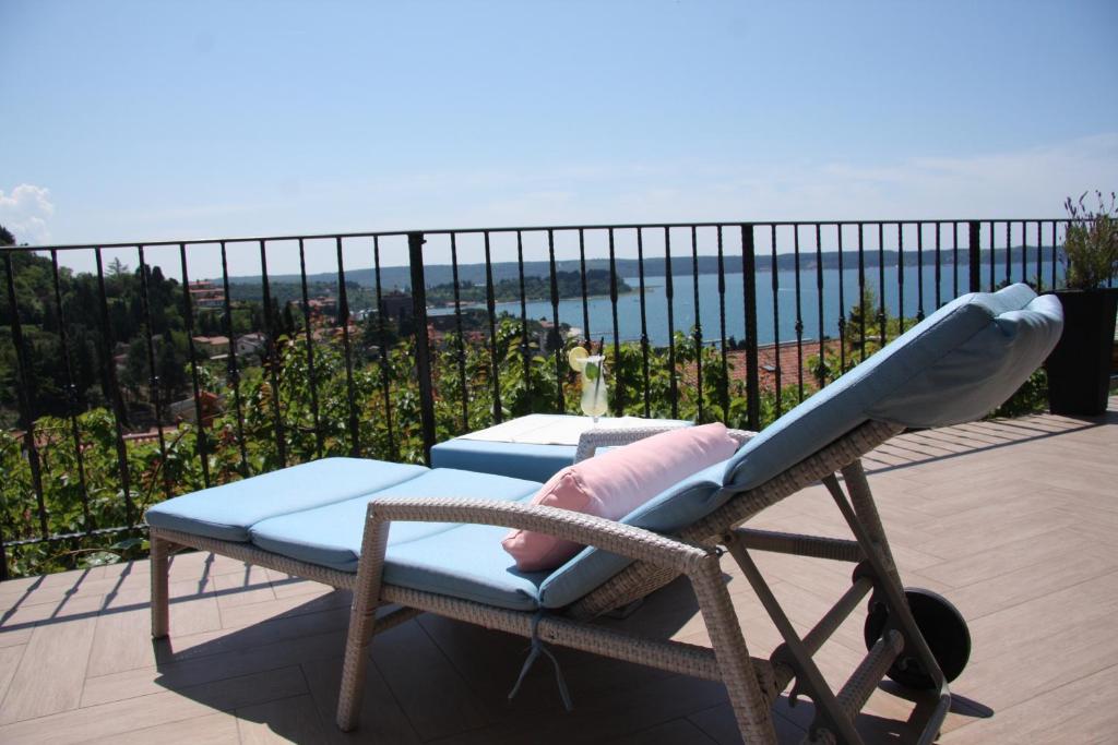 a lounge chair on a balcony with a view of the ocean at Apartment Vrenjak in Portorož