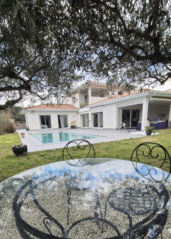 une table en verre devant une maison dans l'établissement La Villa des Oliviers, à Saint-Hippolyte-de-Montaigu