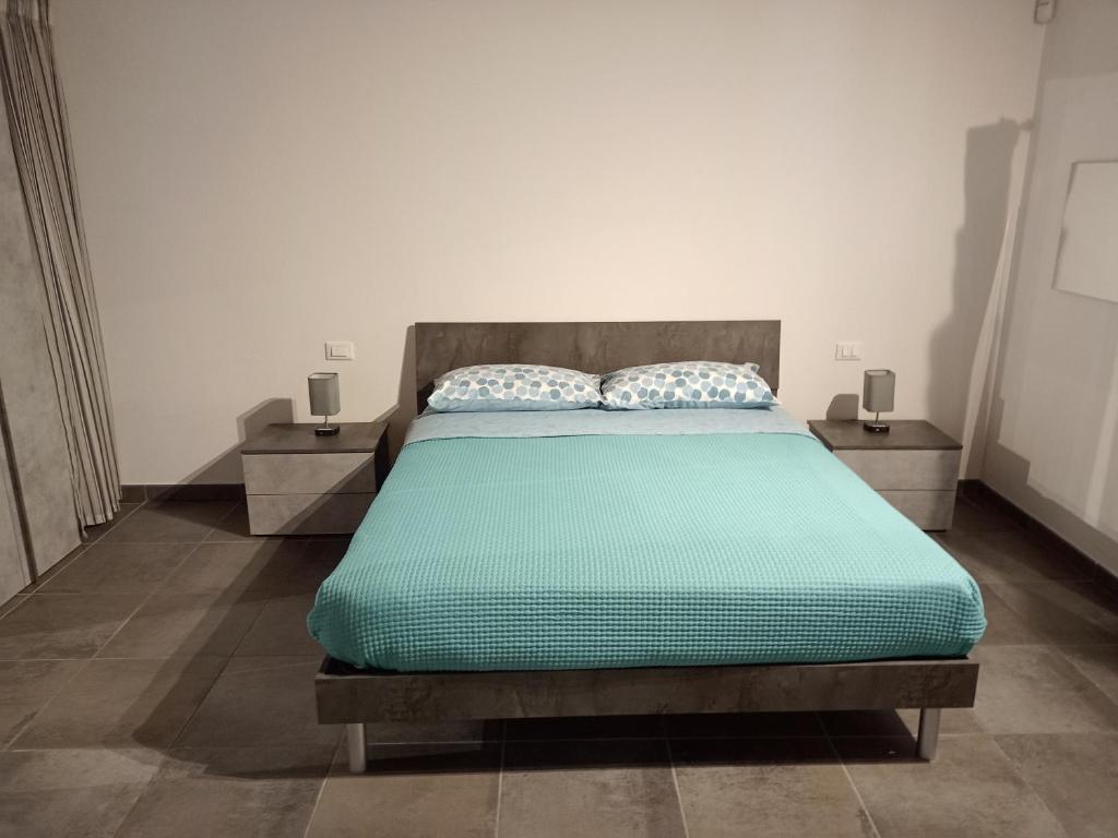 a bedroom with a bed with two night stands at Appartamento in Villa con giardino in Pregnana Milanese