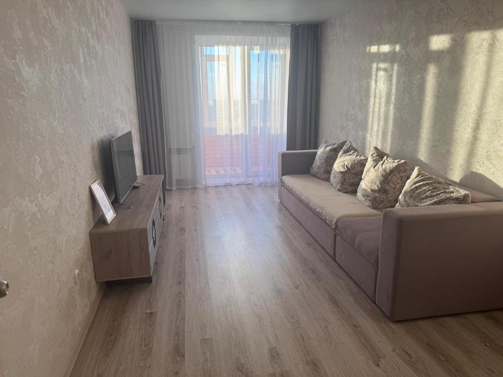 a living room with a couch and a television at 2-х комнатная квартира в районе Костанай плаза in Kostanay