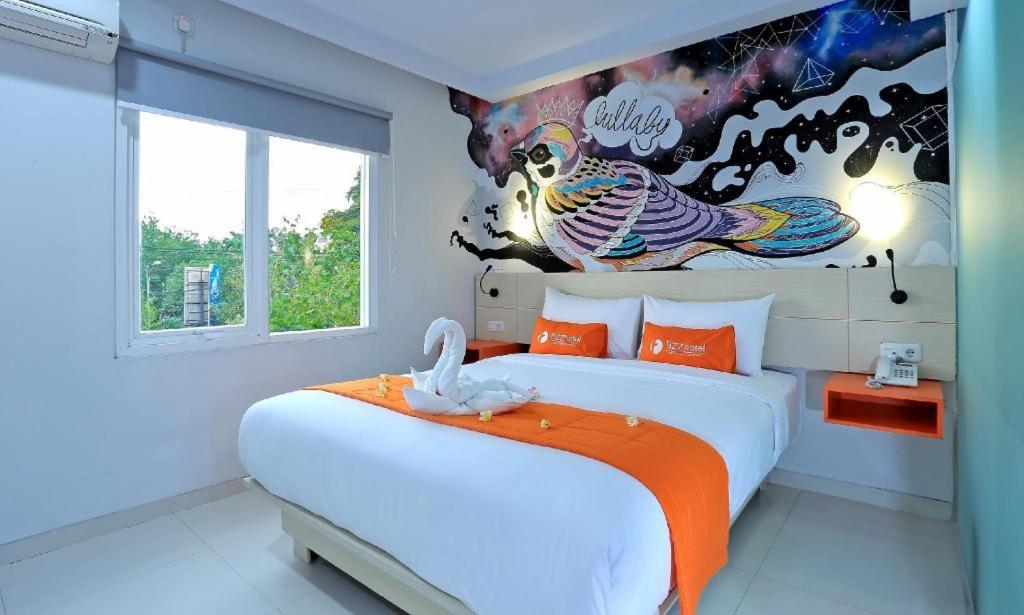 una camera con due letti e un dipinto sul muro di Fizz Hotel Lombok a Gili Trawangan