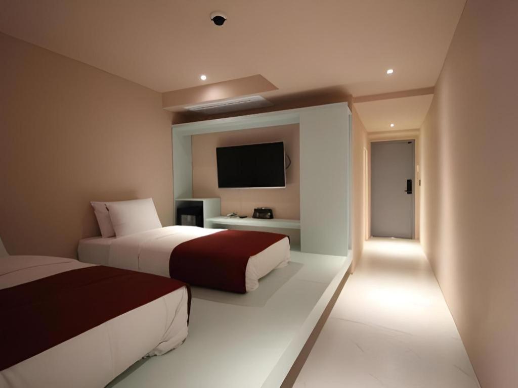 ソウルにあるBobo Hotel Hongdaeのベッドルーム1室(ベッド2台、薄型テレビ付)