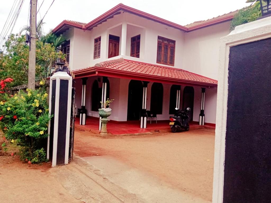 a white and red house with a red roof at WR Family and Holiday Resort in Anuradhapura