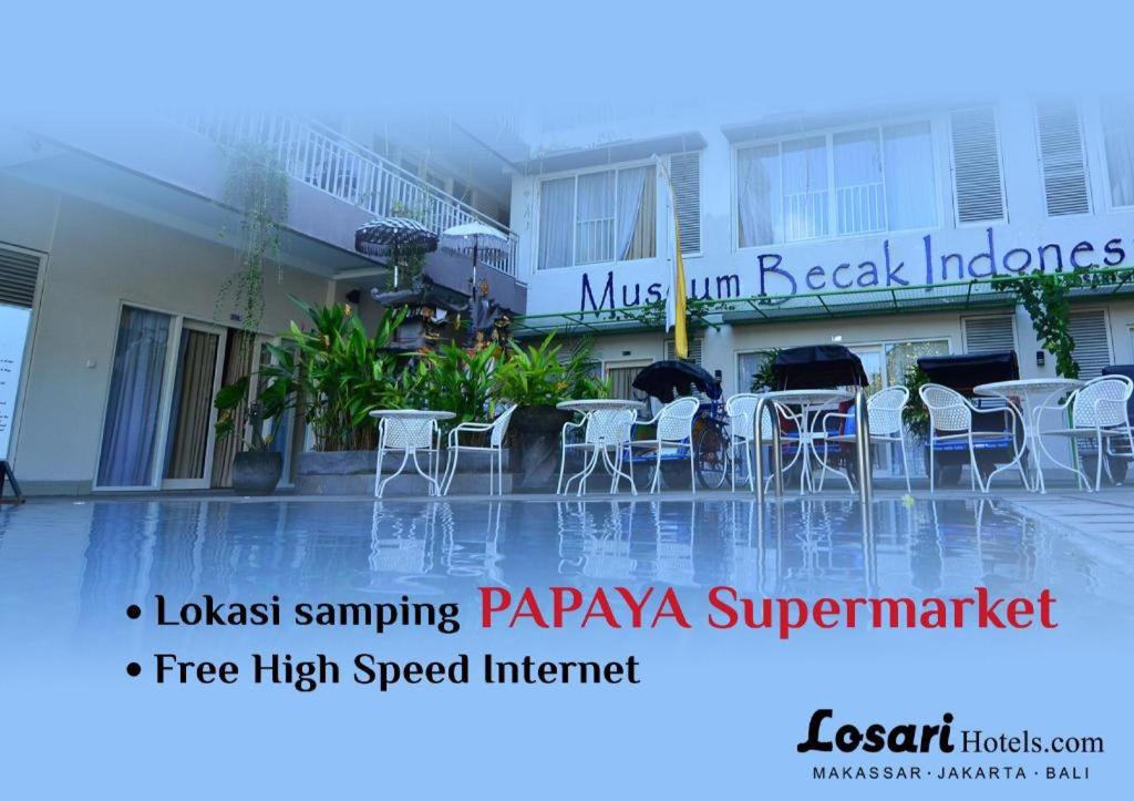 znak dla hotelu ze stołami i krzesłami w obiekcie Losari Sunset Hotel w mieście Kuta