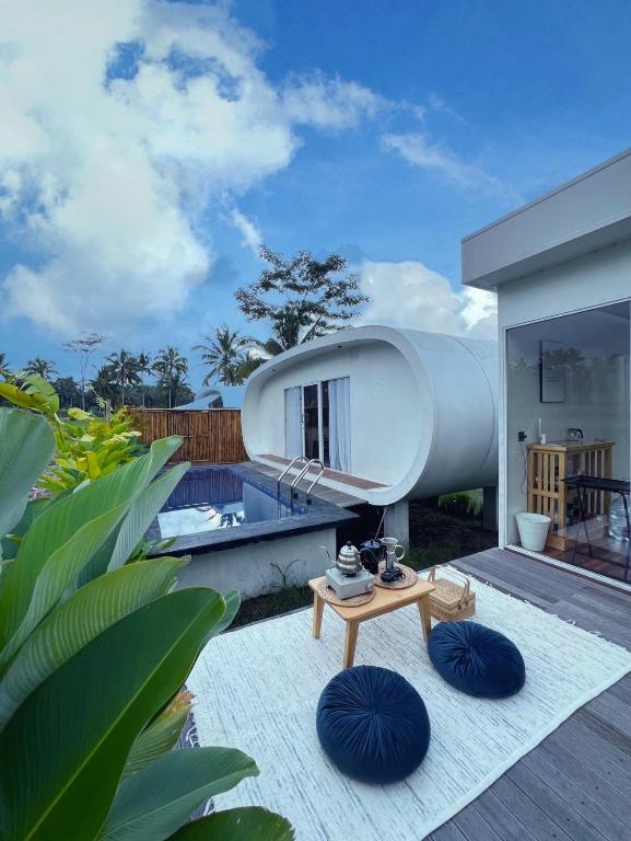 a modern house with a pool and a table at Nira Meraki Aruna in Bedoyo
