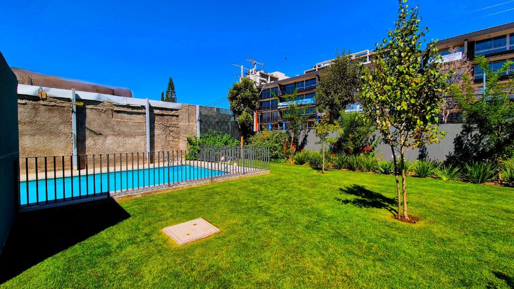 a small tree in a yard with a swimming pool at Moderno y Comodo Departamento en Ñuñoa 2D1B Piso 6 in Santiago