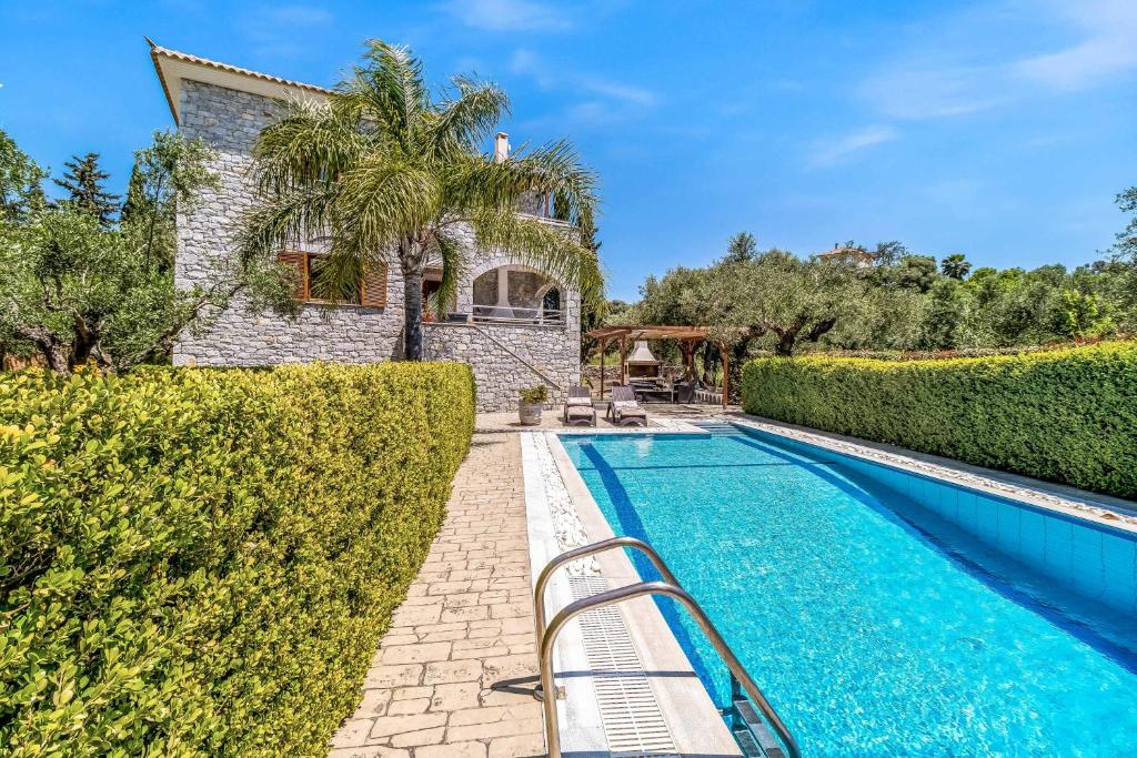 a villa with a swimming pool and a house at Villa Petra in Methoni