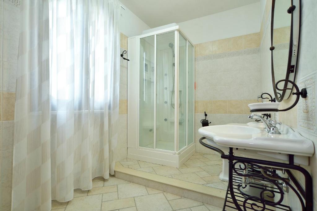 une salle de bain blanche avec une douche et un lavabo dans l'établissement Villa del Colle con piscina privata, à Ispica
