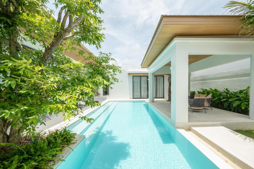 an infinity pool in the backyard of a villa at Mouana Breeze Mai Khao 4-bedroom Pool Villa 9922 in Mai Khao Beach