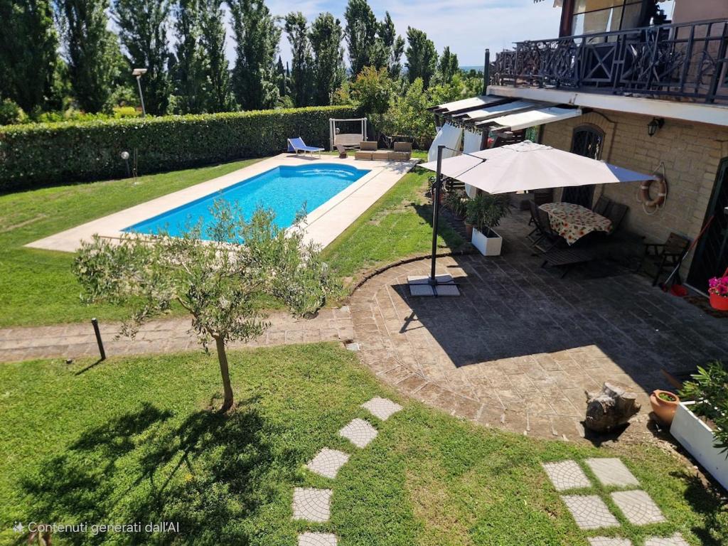 a backyard with a swimming pool and a house at Villa Colle degli Ulivi con piscina e sguardo sul mare in Cerveteri