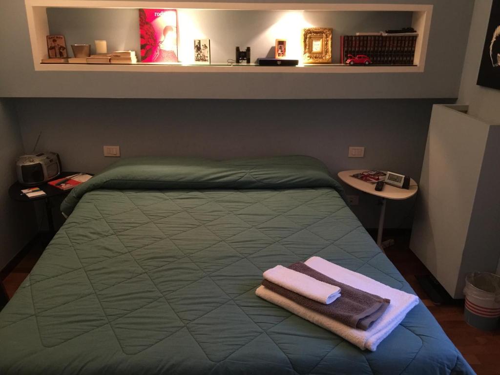 a bedroom with a bed with two towels on it at Casa Albert Stanley in Bologna