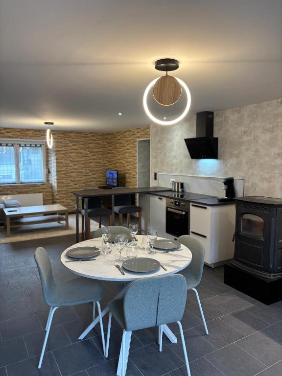 une cuisine et une salle à manger avec une table et des chaises dans l'établissement Le repos du voyageur, à Rolampont