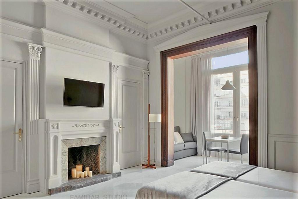 a white bedroom with a fireplace and a television at Casa Abamita in Barcelona