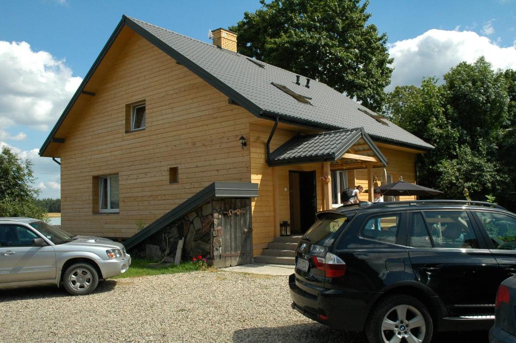 ein Haus mit einem davor geparkt in der Unterkunft Przystanek Rospuda in Sucha Wieś