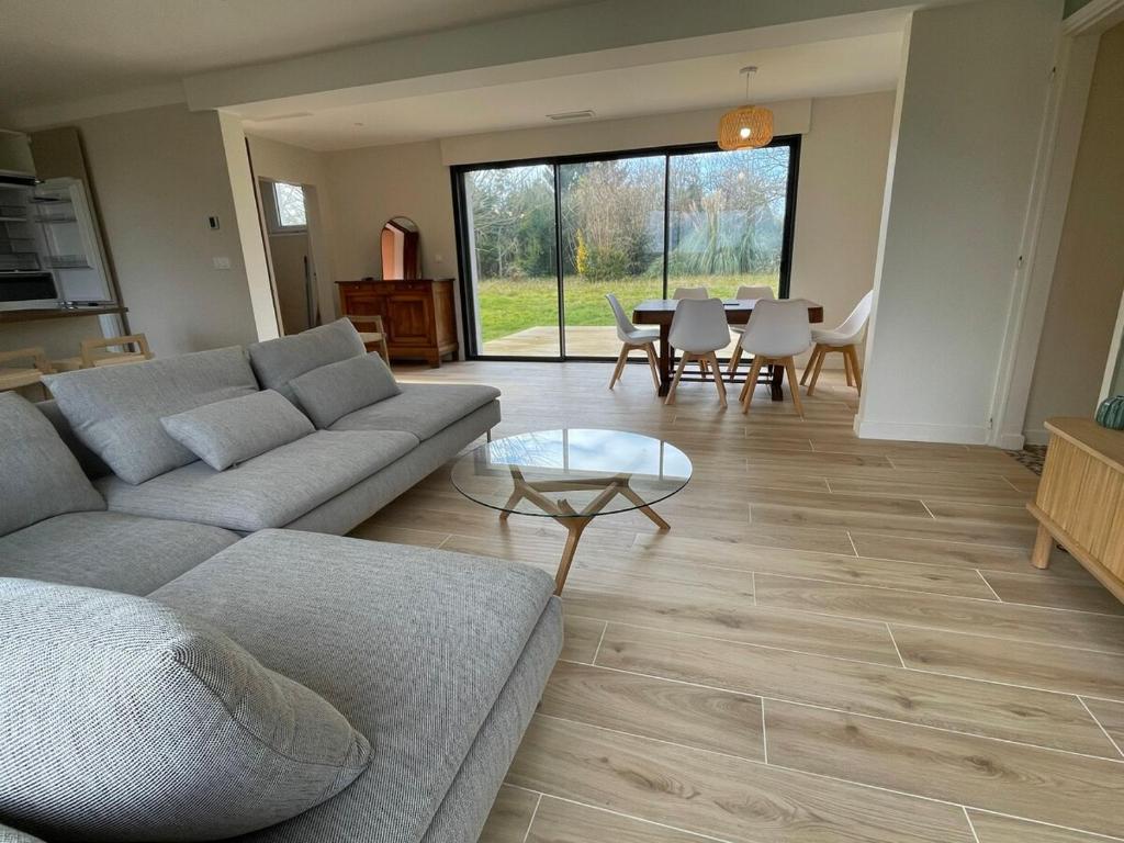 un salon avec un canapé et une table dans l'établissement Le 102 - Cozy, quiet one-story house in Mées, à Mées