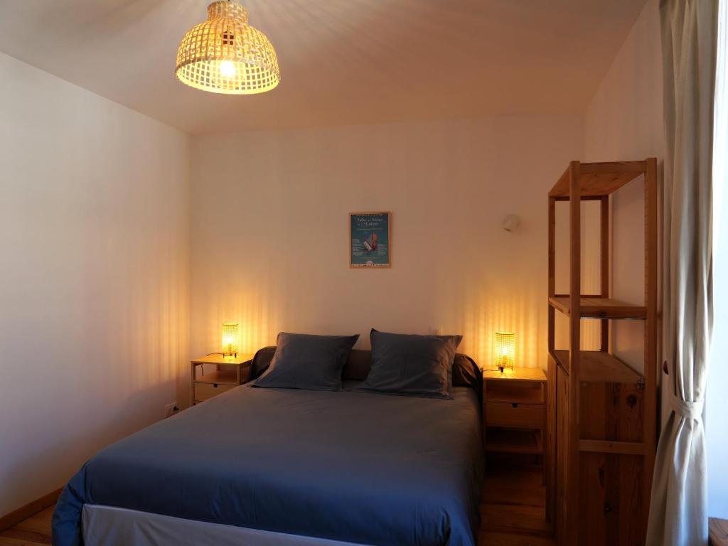 a bedroom with a blue bed and two lamps at La Malavisée in Tournavaux